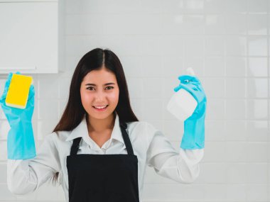 Mutfaktaki temizlik masasına lastik eldiven takan kadın. Temizlik konsepti.