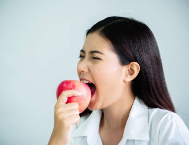 Beyaz arka planda izole ofis mutlu ile diyet için bir elma ısırmak güzel kadın yakın. Yeme ve sağlık konsepti.