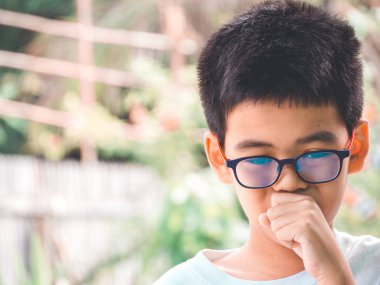 Asyalı çocuk öksürük ve iyi hissetmiyor. Soğuk algınlığı ya da bronşit belirtileri gibi. Sağlık hizmetleri kavramı.