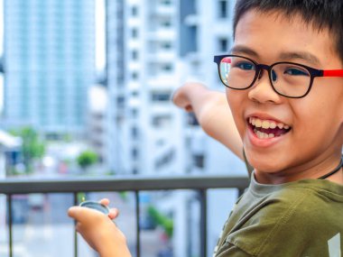 Asyalı çocuk pusulayı tutuyor ve hedefi işaret ediyor.. 