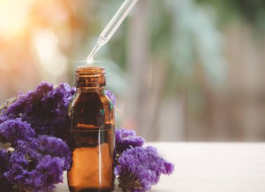 Temel yağ, cam damlacıktan kahverengi şişeye, organik biyolojik alternatif tıbba dökülüyor. Güzellik ve Spa Konsepti. 