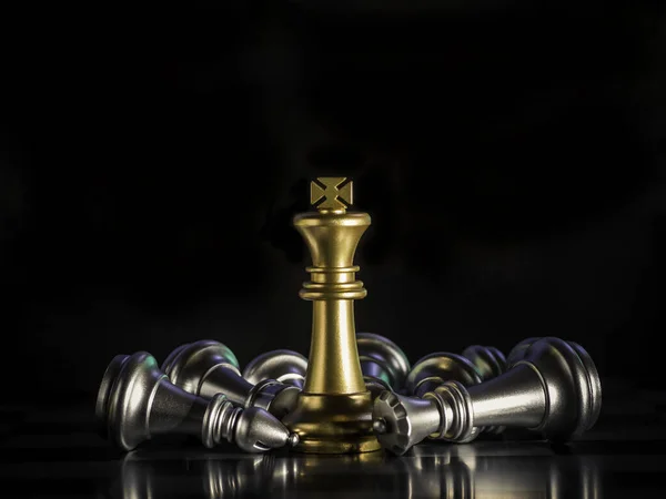 Golden king chess is surrounded by falling around silver chess pieces  to fighting with teamwork to victory, business strategy concept and leader and teamwork concept for success.