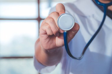 Erkek doktor, hastane geçmişinde göğsüne steteskop tutuyor. Doktor hastayı muayene etmeye hazır. Tıbbi ve hasta bakımı kavramı.