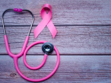 Pembe kurdele ve steteskop ahşap masa tarzı. Göğüs kanseri sembolü, sağlık hizmeti konsepti