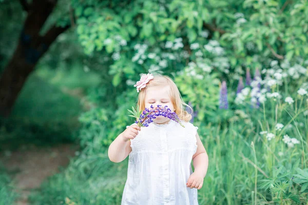 Una Chica Rubia Años Con Vestido Blanco Huele Una Flor —  Fotos de Stock