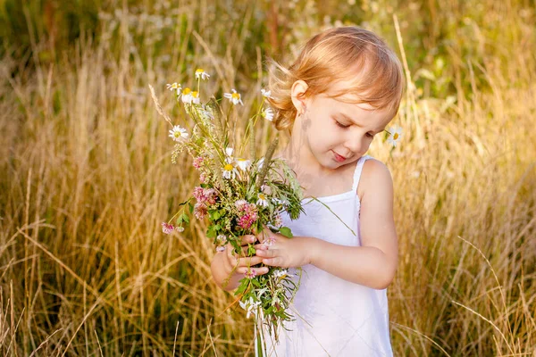 Una Niña Años Vestido Blanco Sostiene Ramo Flores Silvestres Sobre —  Fotos de Stock