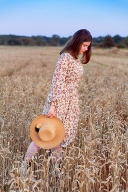 Genç bir kadın bej rengi ipek bir elbiseyle poz veriyor.. 