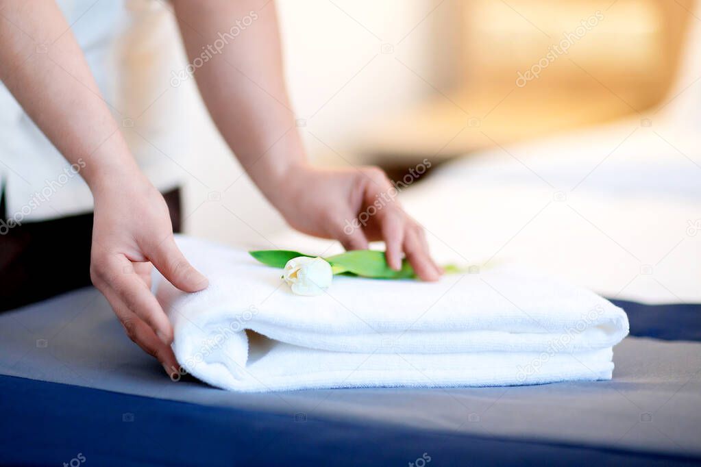 The maid puts a towel in a hotel room