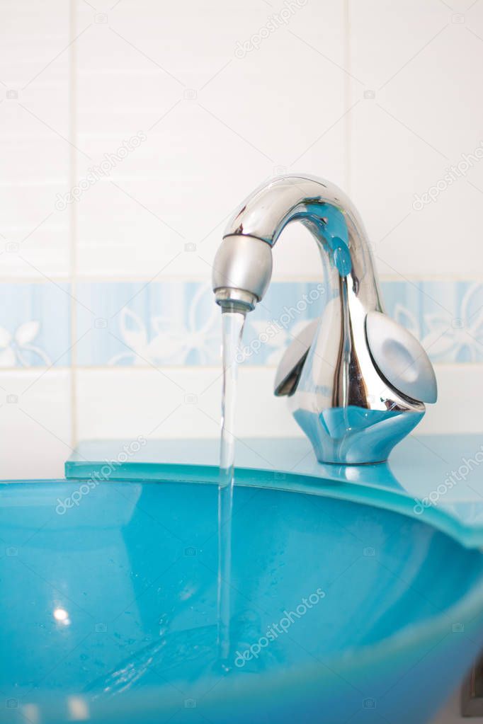 Chrome faucet on a modern blue sink.