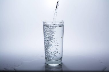 Masadaki bardağa temiz içme suyu dökün. Close.