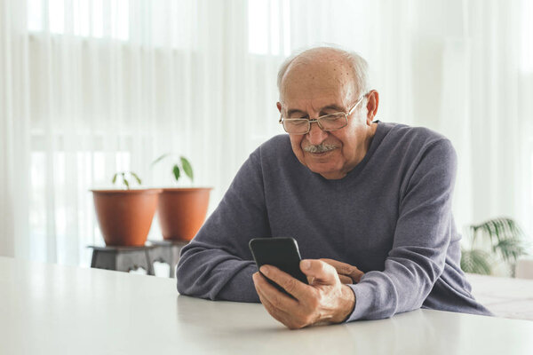 Retired man using computer technologies at home. 
