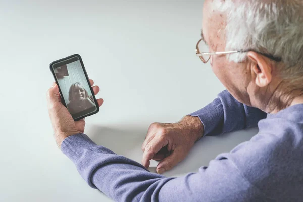 Retired man using computer technologies at home.