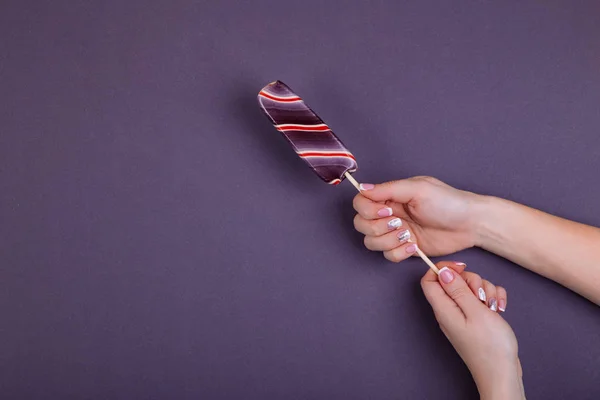 Paleta en un palo en la mano . — Foto de Stock