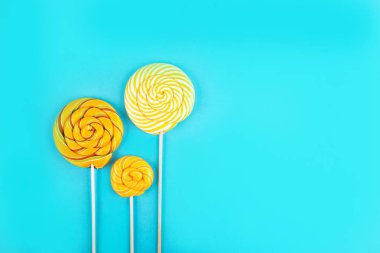 Arka planda üç renkli lolipop.