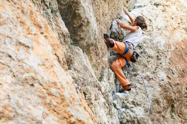 Woman climbs mountain.