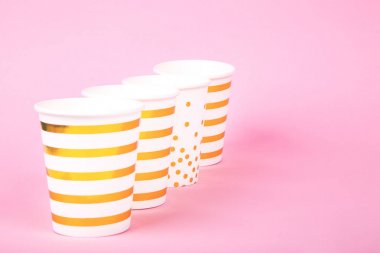 Pembe arka plan üzerine kağıt bardak. 