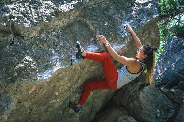 Girl climbing boulder.