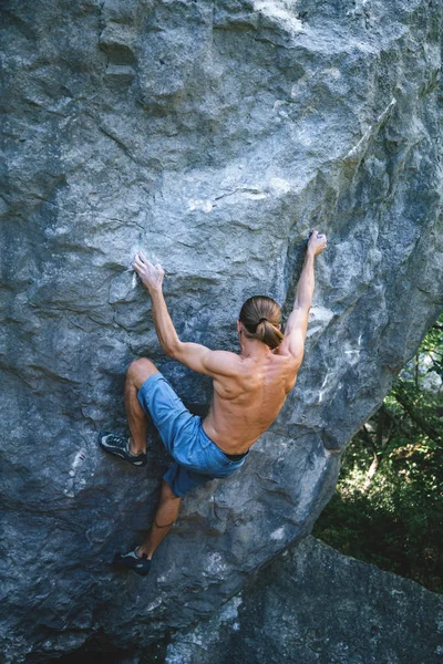 Man climbing boulder.