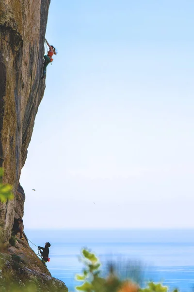 Pessoas escalando montanha de rocha . — Fotografia de Stock