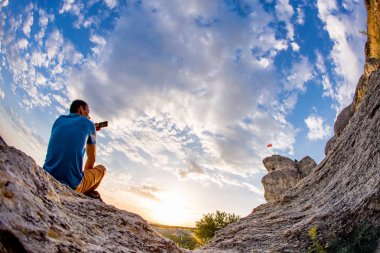 Adam bulut gökyüzü arka plan karşısında duruyor.