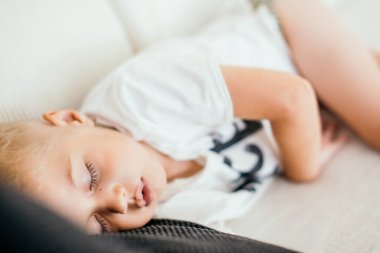 Çocuk bir kanepede uyuyor.