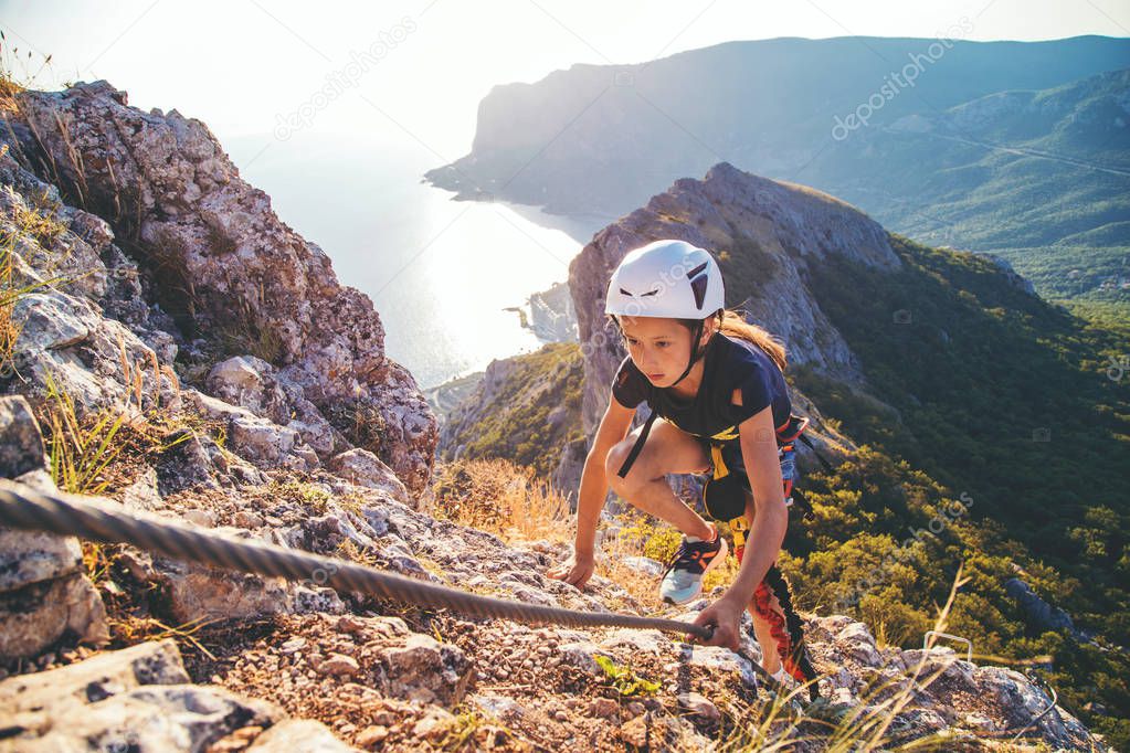 Kid girl climbing mountain. 