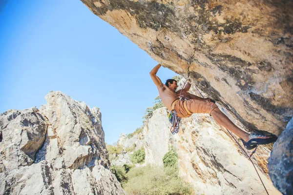 Mann klettert auf einen Felsen. — Stockfoto