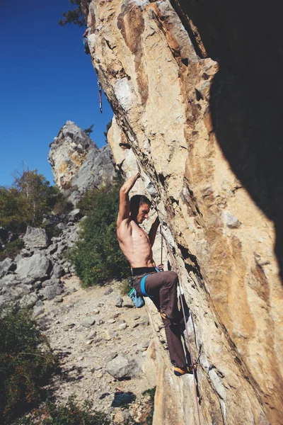 Uomo arrampicata su una roccia. — Foto Stock