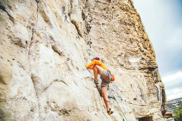 Девушка, взбирающаяся на скалу. — стоковое фото