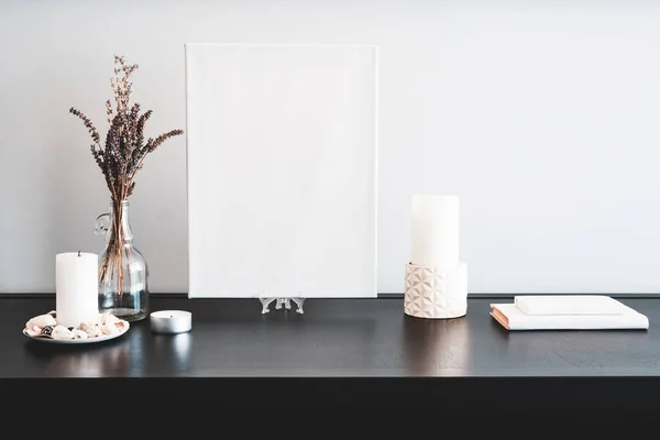 乾燥した花の花束 キャンドル 黒いテーブルと白い壁に白い本を持つアーティストのモックアップ ガラス瓶花瓶のための空白の白いキャンバス ミニマリズム — ストック写真