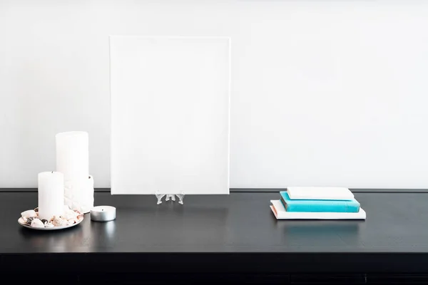 黒テーブルと白の壁にアーティストのモックアップ キャンドル 白と青の本のための空白の白いキャンバス ミニマリズム — ストック写真