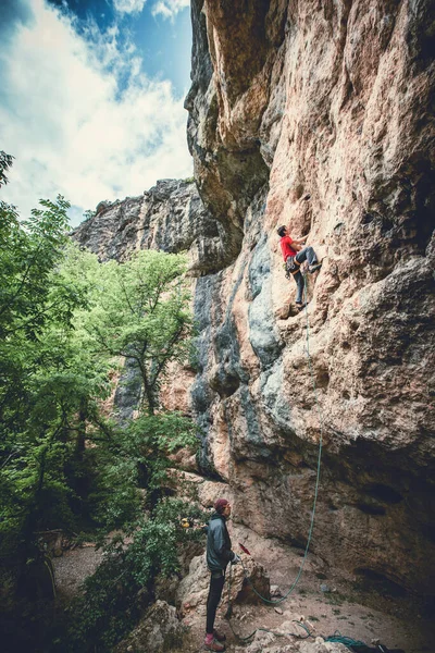 Uomo arrampicata su una roccia. — Foto Stock