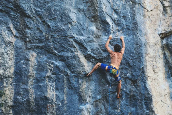 L'homme grimpe un rocher. — Photo