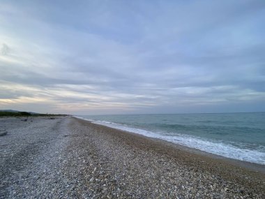 Gün batımında Adriyatik kıyısındaki Abruzzo 'da sakin dalgalar, sakin ve görkemli bir manzara yaratıyor.