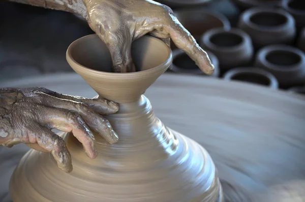 Гончар робить коричневий глиняний горщик своїми руками на гончарному колесі — стокове фото