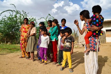 Kolayat, Bikaner, Rajasthan / Hindistan: 11 / 04 / 2018, bir grup kırsal çocuk çamurdan kulübenin önünde duruyor
