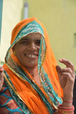 Bikaner, Rajasthan / Hindistan, Ekim 19.2019: Kapıda geleneksel takı ve geleneksel Rajasthani elbisesiyle dikilen bir kadın Gangeshahar, Bikaner 'in evinde görülüyor