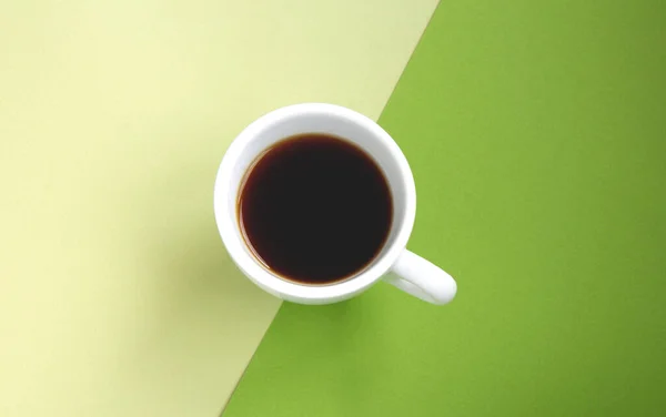 Schwarzer Kaffee in einer weißen Tasse auf grünem Hintergrund — Stockfoto