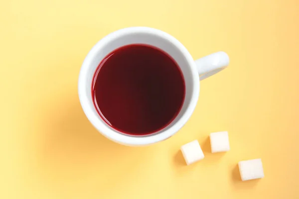 Roter Hibiskustee in einer weißen Tasse mit Zuckerwürfeln — Stockfoto
