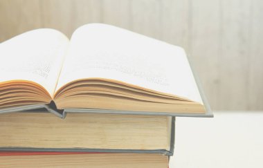 Bir yığın eski ciltli kitap ve açık kitap. Bir sürü kitap yığını. Açık masa görünümünde sert ciltli kitaplar