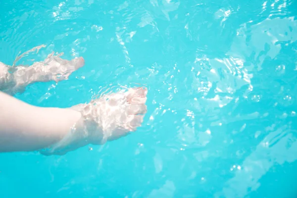 Niños piernas en la piscina. Vacaciones de verano — Foto de Stock