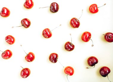 Beyaz arka planda parlak kırmızı kiraz. Kiraz deseni. Kirazlar yakın plan. Yaz yassı böğürtlen arka planı. Üst görünüm