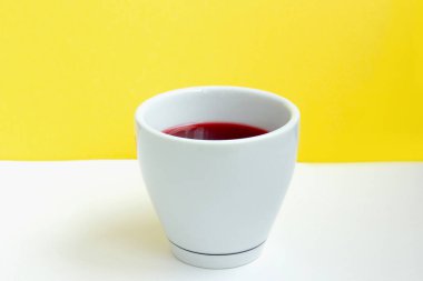 Beyaz bardakta kırmızı amber çayı.