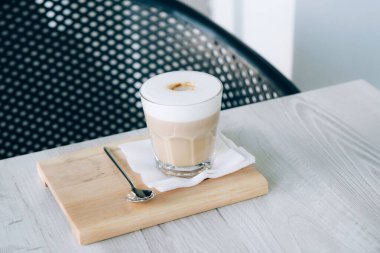 Ahşap tepside cam bir bardakta Latte ya da Cappuccino
