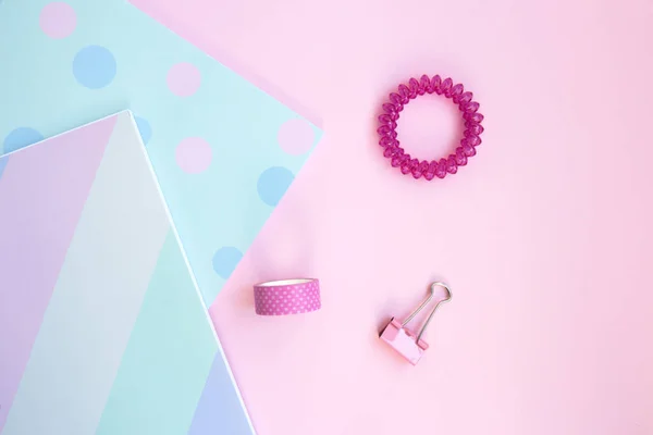 İki parlak eskiz kitabı, seloteyp, pembe ataç ve pembe arka planda saç teli. Pembe arka planda kırtasiye malzemesi, mesaj için yer var. Okula, yaratıcı çalışma alanına. Düz yatıyordu