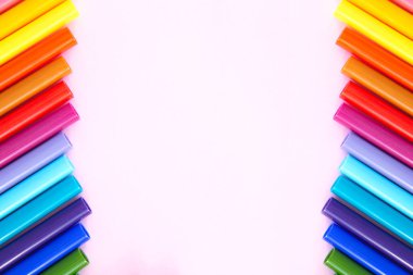 Açık pembe arka planda renkli kalem seti. Tasarımınız ya da montajınız için canlı işaretleyiciler ve boş boşluk. Kırpma yolu olan bir arka plan. Düz yatıyordu