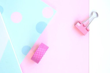 Parlak eskiz defterleri, selobant, pembe arka planda pembe ataç ve beyaz kağıt. Pembe arka planda kırtasiye malzemesi, mesaj için yer var. Okula, yaratıcı çalışma alanına. Düz yatıyordu