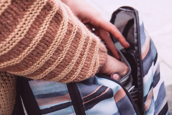 居心地の良いベージュのセーターの女の子は 多色のバックパックに物事を置きます 荷物を — ストック写真
