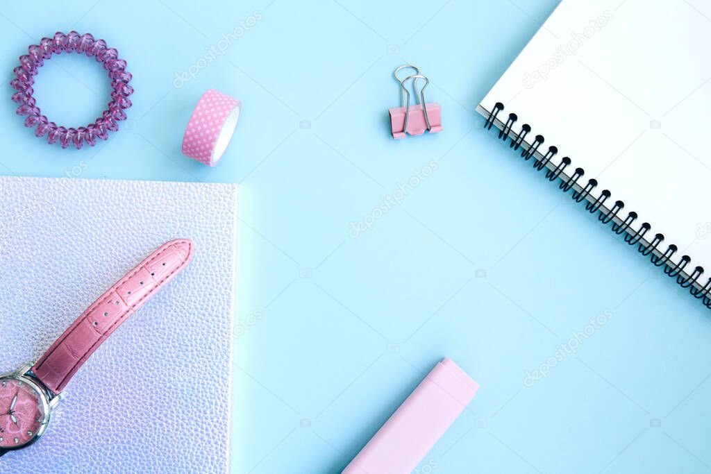 Pink set for girls. Neon notebook, scotch tape, watch, clips, eraser, open notepad and hair tie on a pink background with space for text. Getting ready for school. Creative workspace. Flat lay
