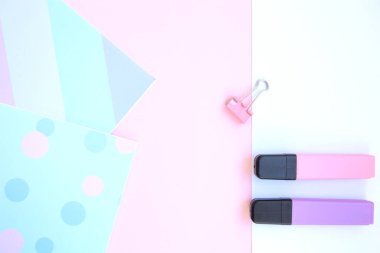 Parlak eskiz defterleri, iki kalem, pembe ataç ve pembe arka planda beyaz kağıt. Okula hazırlanıyorum. Yaratıcı çalışma alanı. Metin için alanı olan düz kırtasiye yatağı